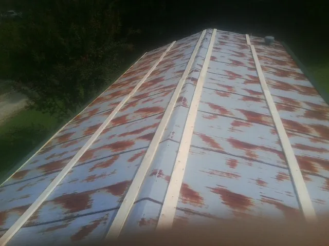 Rusted metal roof panels with new wood purlins before replacement — Storm Damage Roof Repair in Ansonville by Roofing Brothers