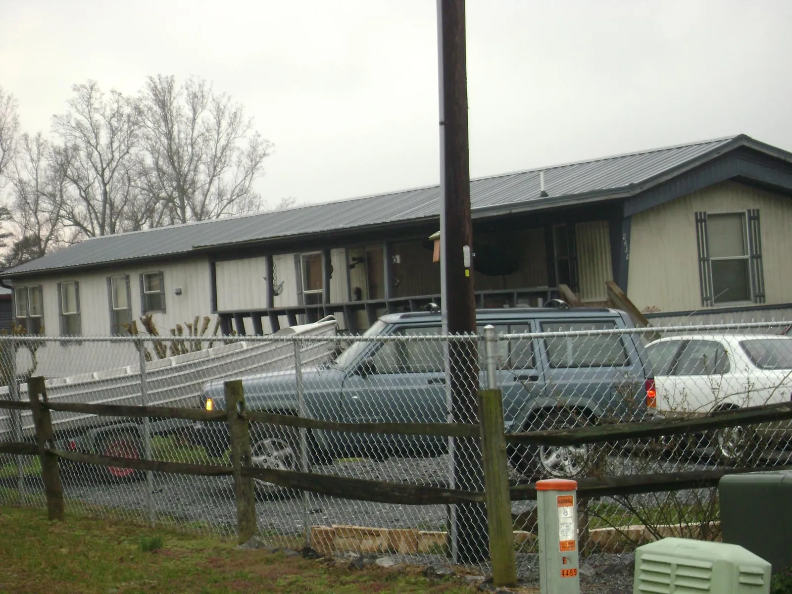 Dark metal roof on a long single story building behind a chain link fence in Ansonville