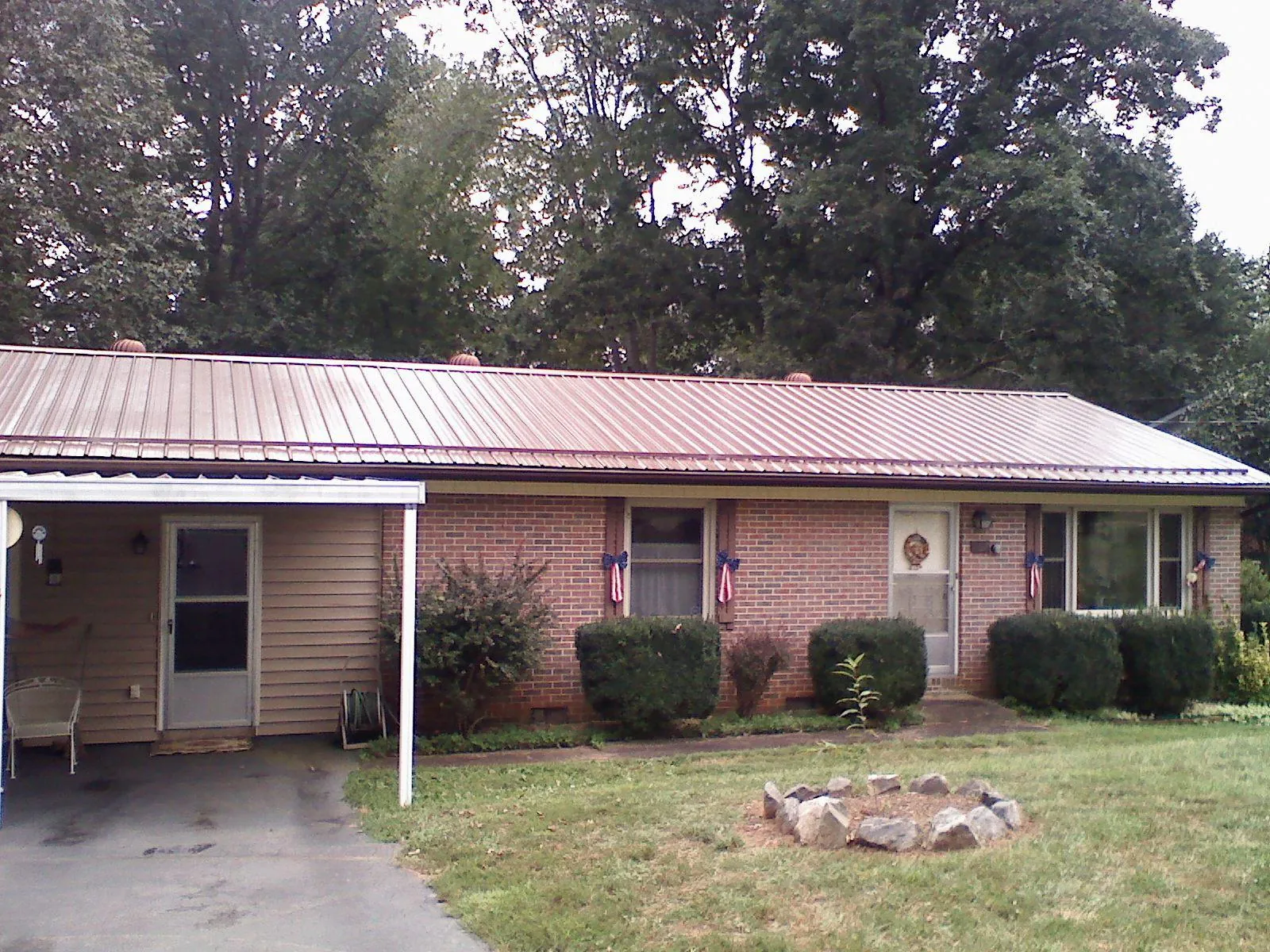 Bronze metal roof and carport on a brick ranch home — Roof Repair work by our crew in Ansonville